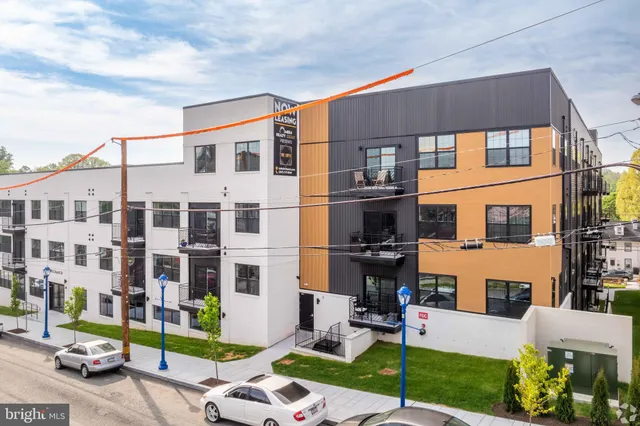 a front view of a building with a garden and plants