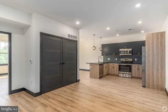 a kitchen with stainless steel appliances kitchen island granite countertop a refrigerator and a stove top oven