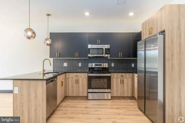 a kitchen with stainless steel appliances granite countertop a refrigerator and a stove top oven