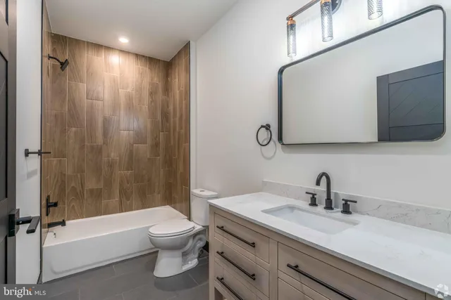 a bathroom with a granite countertop sink a toilet and a bathtub