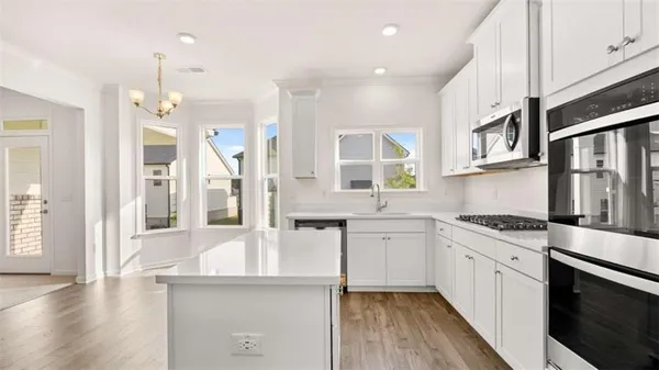a kitchen with stainless steel appliances granite countertop a stove and cabinets