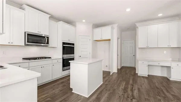 a kitchen with cabinets stainless steel appliances and wooden floor