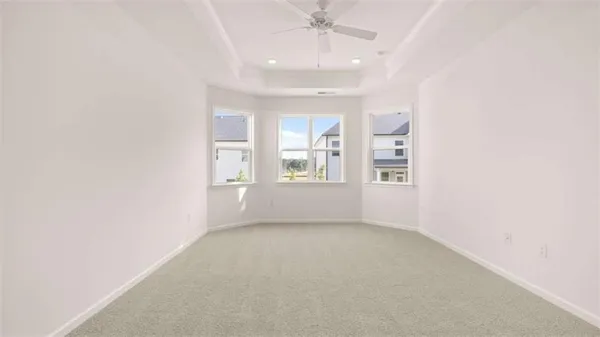 an empty room with windows and chandelier fan