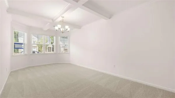 an empty room with windows and chandelier