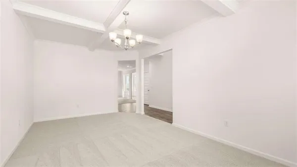 a view of an empty room with a chandelier fan