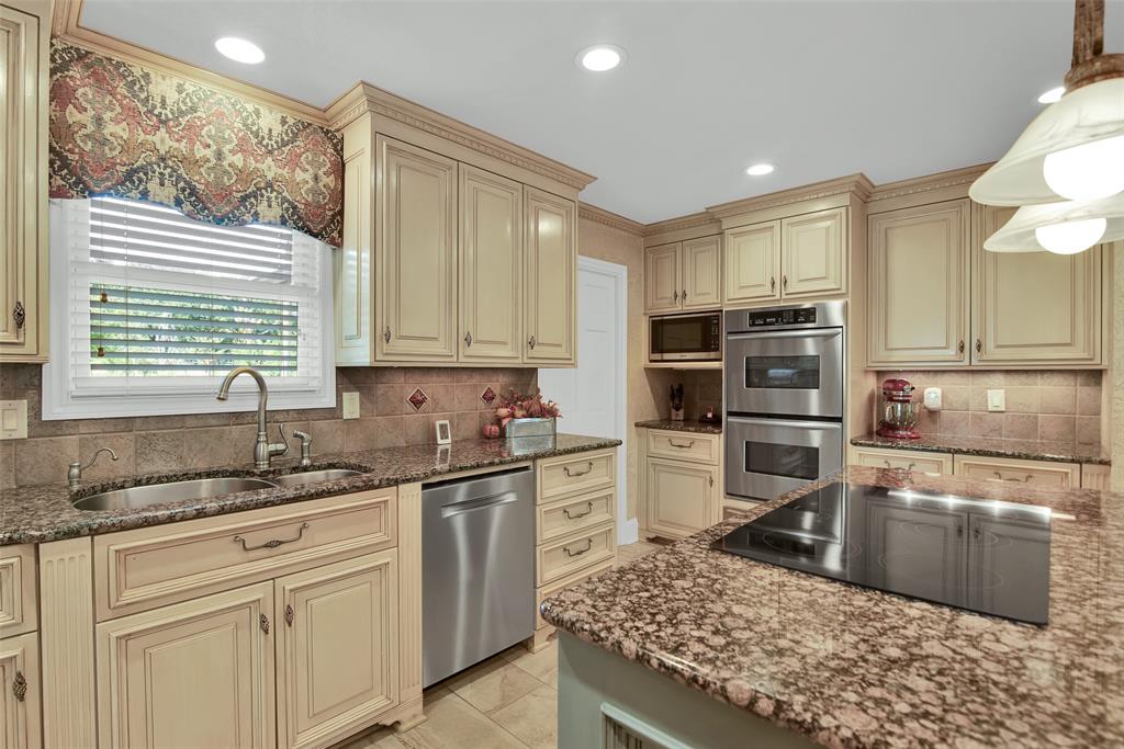 649 Anderson Road Whitesboro, TX 76273 - Photo 13 of 40 a kitchen with kitchen island granite countertop a sink cabinets and stainless steel appliances