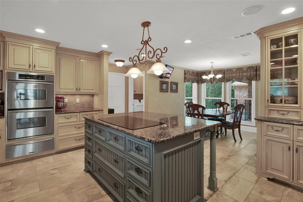 649 Anderson Road Whitesboro, TX 76273 - Photo 14 of 40 a kitchen with kitchen island granite countertop a table chairs stainless steel appliances and cabinets