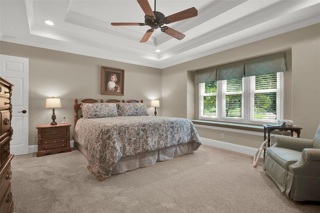 649 Anderson Road Whitesboro, TX 76273 - Photo 20 of 40 a spacious bedroom with a large bed and a chandelier
