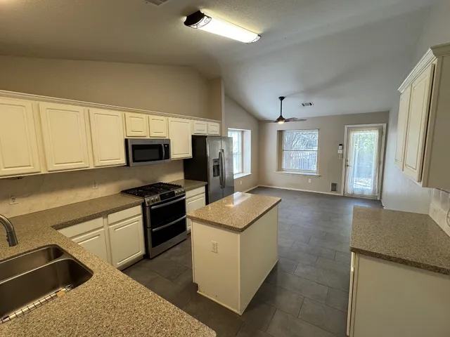 a kitchen that has a sink and a stove in it