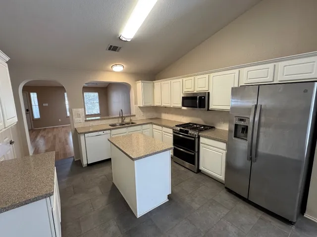 a kitchen with a sink stove and refrigerator