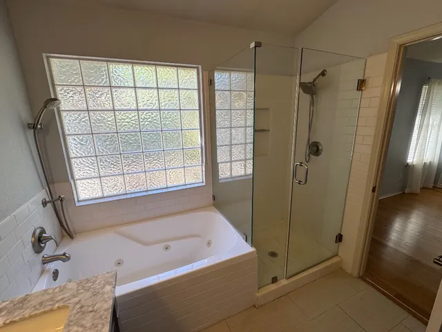 a bathroom with a tub a sink and a shower
