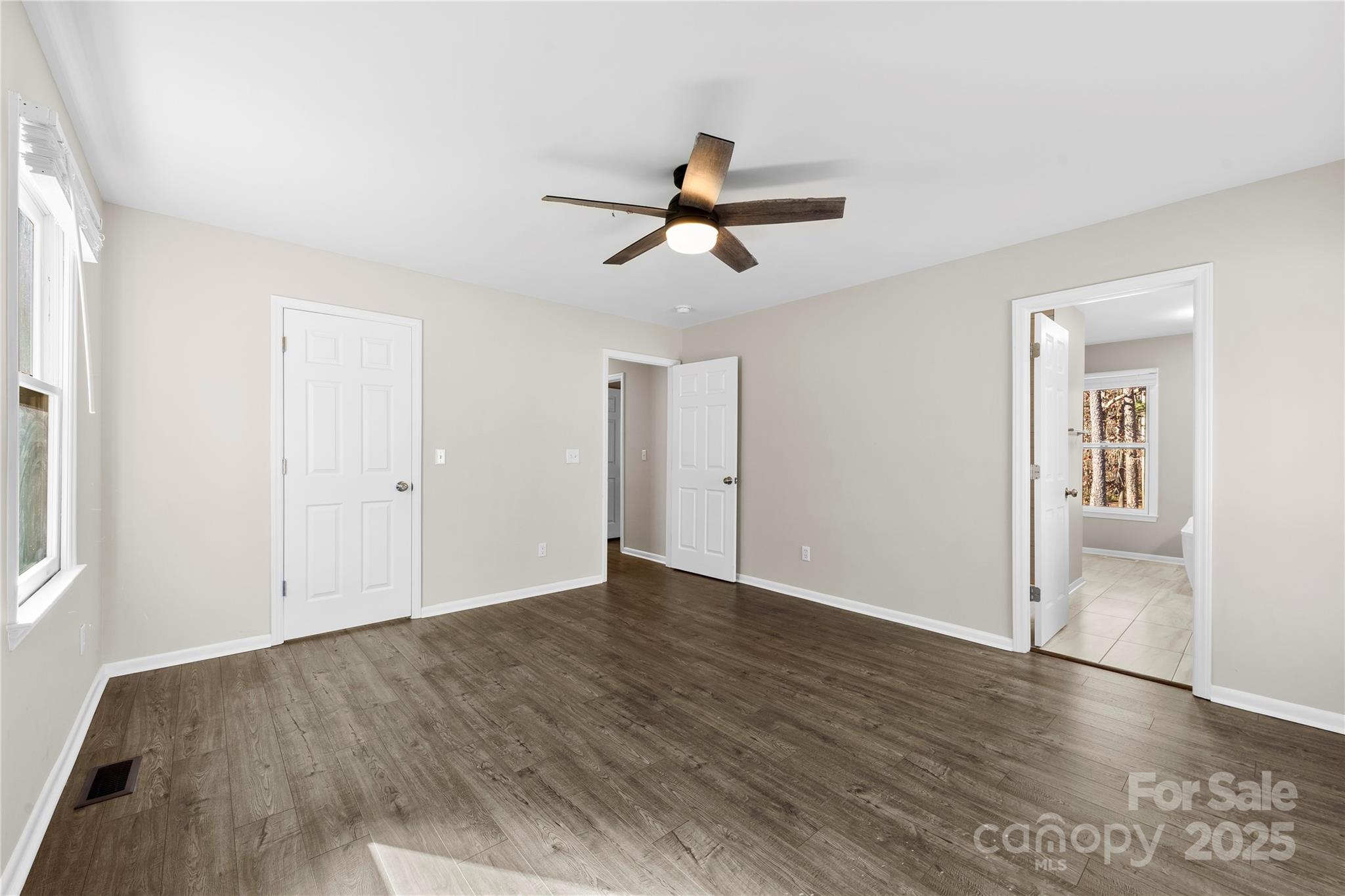 16218 Barbee Road Stanfield, NC 28163 - Photo 13 of 30 an empty room with wooden floor and windows