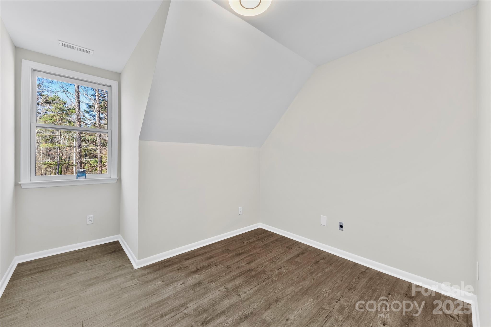 16218 Barbee Road Stanfield, NC 28163 - Photo 21 of 30 an empty room with wooden floor and windows