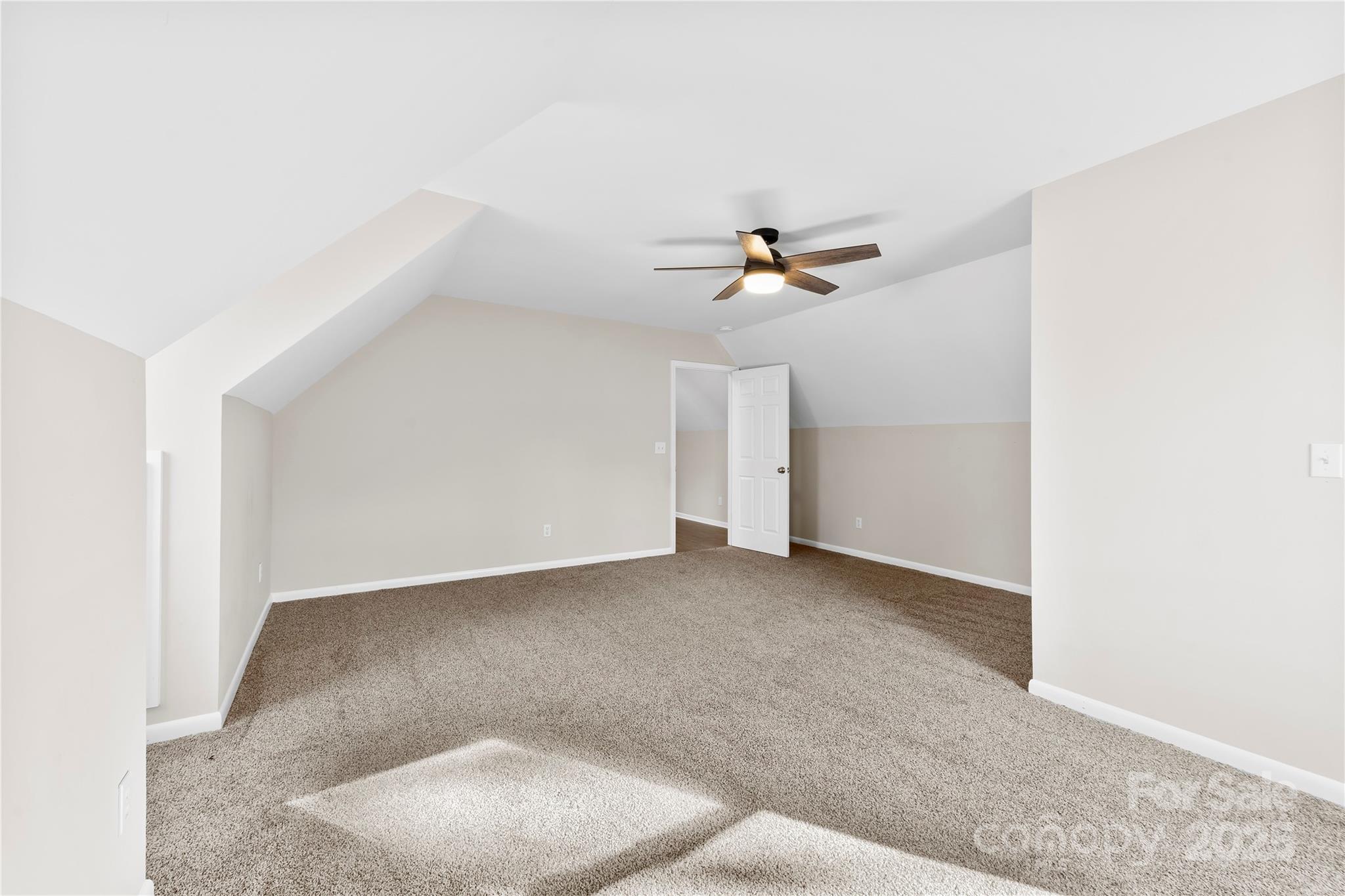 16218 Barbee Road Stanfield, NC 28163 - Photo 22 of 30 an empty room with a ceiling fan and carpet