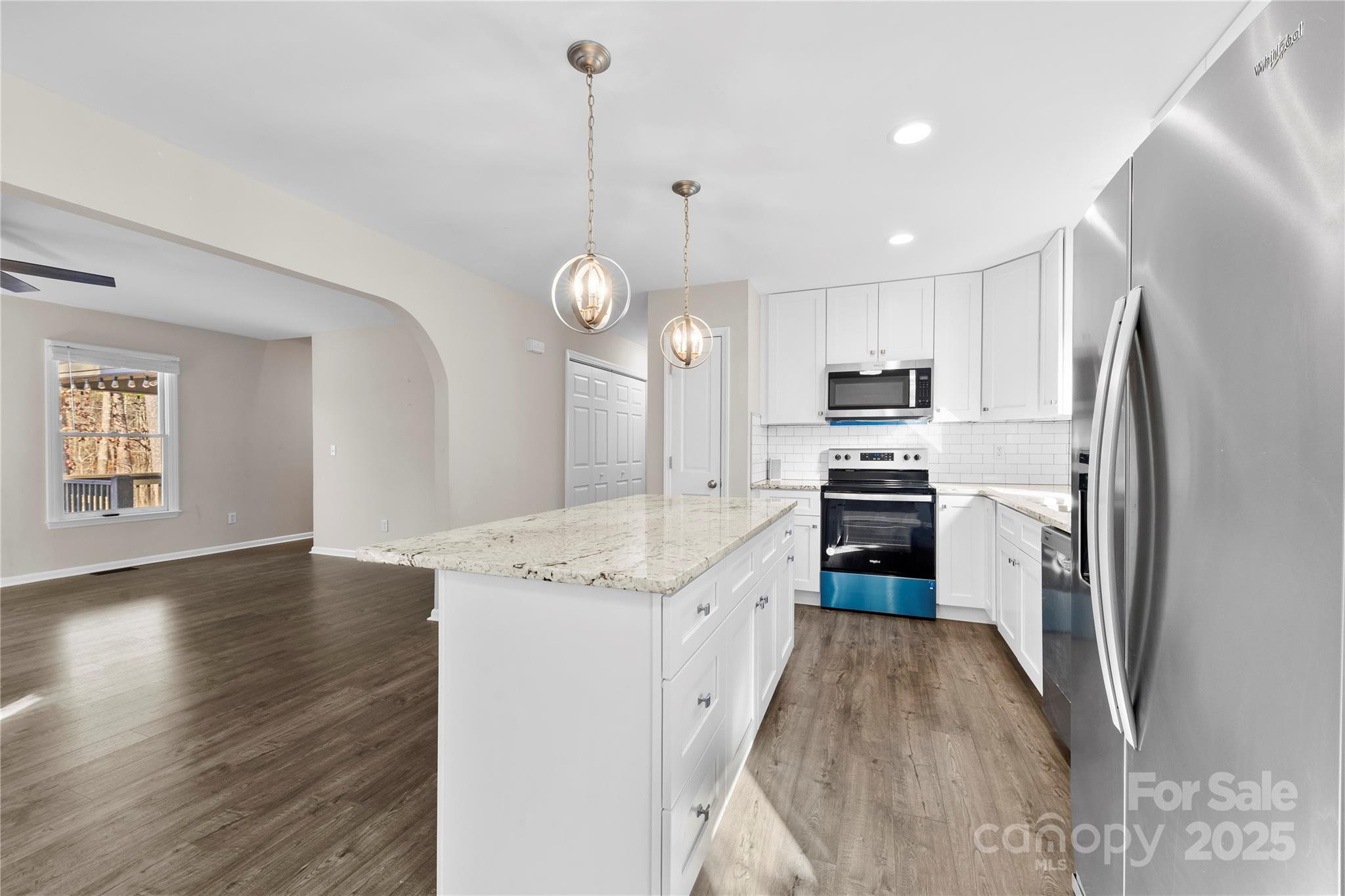 16218 Barbee Road Stanfield, NC 28163 - Photo 6 of 30 a kitchen with stainless steel appliances granite countertop a refrigerator a stove top oven a sink dishwasher and a refrigerator with wooden floor