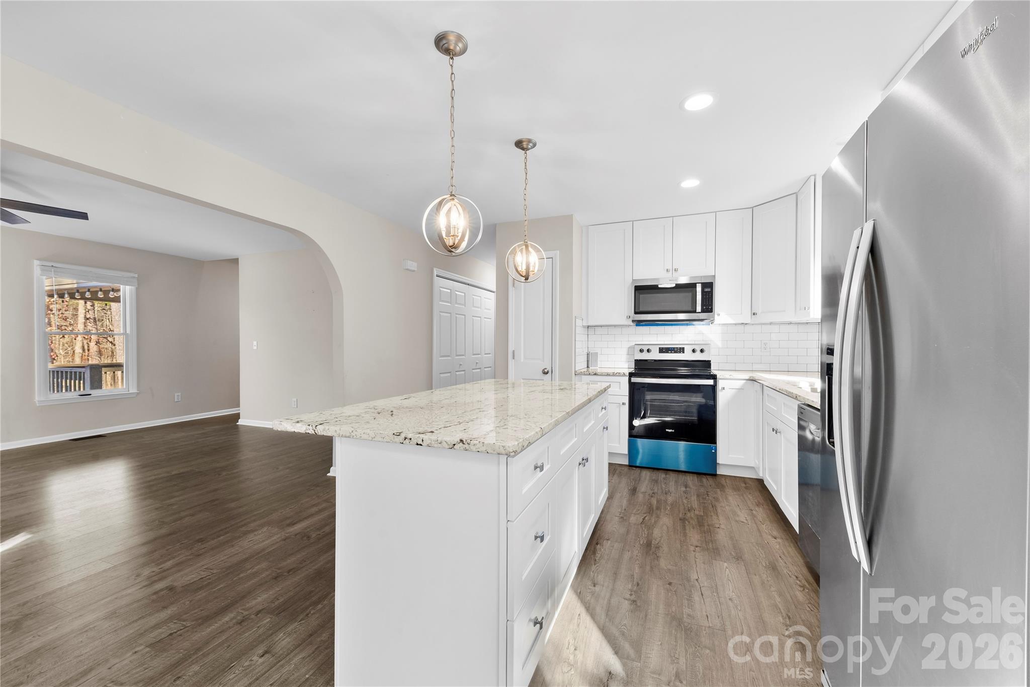 16218 Barbee Road Stanfield, NC 28163 - Photo 7 of 30 a kitchen with stainless steel appliances granite countertop a refrigerator a stove top oven a sink dishwasher and a refrigerator with wooden floor