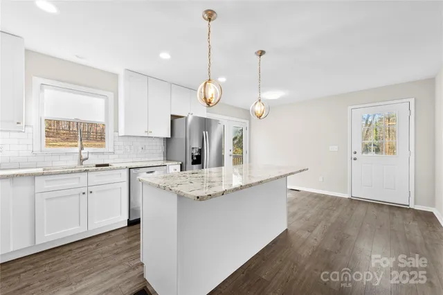 a view of a kitchen with a window and stainless steel appliances