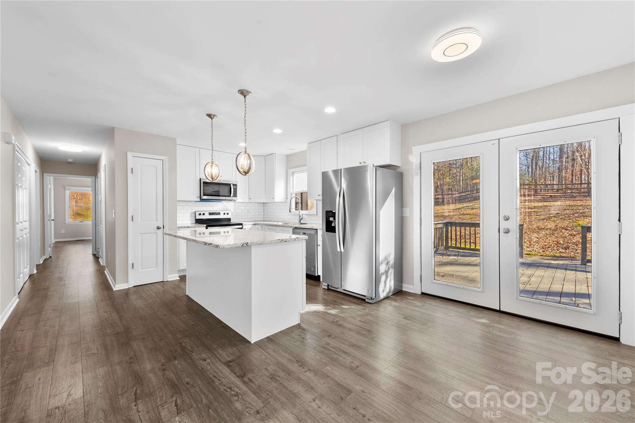 16218 Barbee Road Stanfield, NC 28163 - Photo 10 of 30 a kitchen with stainless steel appliances a refrigerator and wooden floor
