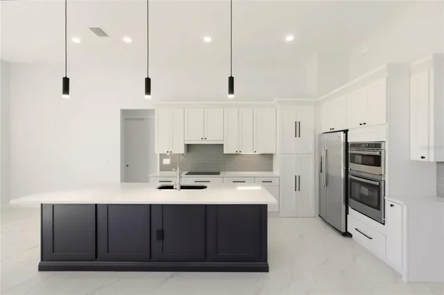 a kitchen with white cabinets and stainless steel appliances