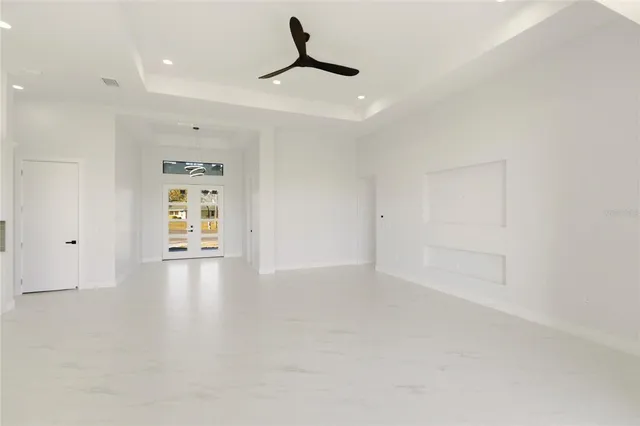 a large kitchen with stainless steel appliances a large counter top a refrigerator a sink and a dresser