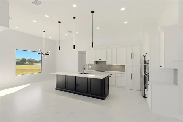 a view of kitchen with stainless steel appliances granite countertop cabinets and a view of living room