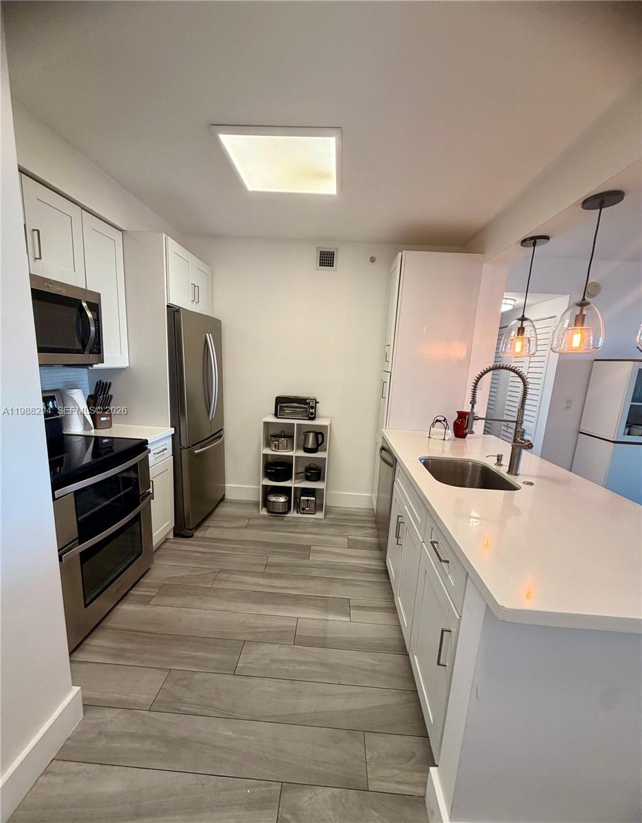 900 Southwest 8th Street, Unit 1509 Miami, FL 33130 - Photo 12 of 37 a kitchen with refrigerator a stove and a sink