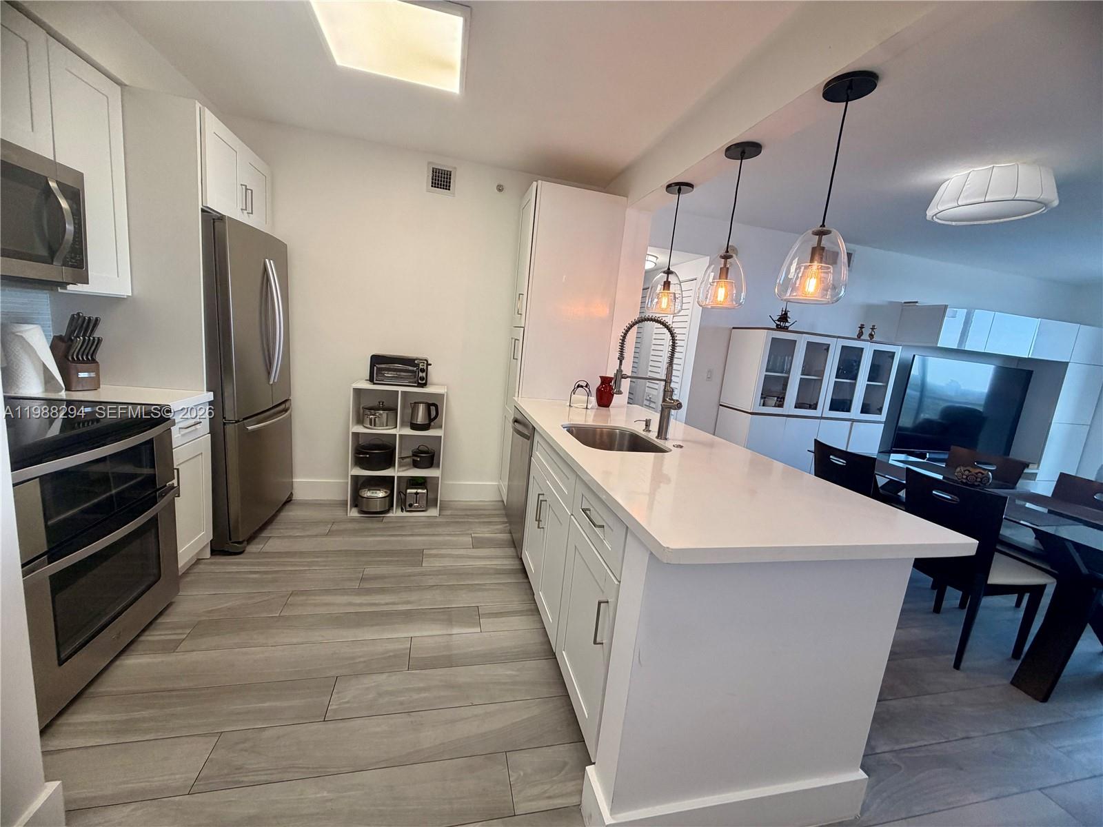 900 Southwest 8th Street, Unit 1509 Miami, FL 33130 - Photo 13 of 37 a large kitchen with kitchen island a stove a sink a oven and a refrigerator