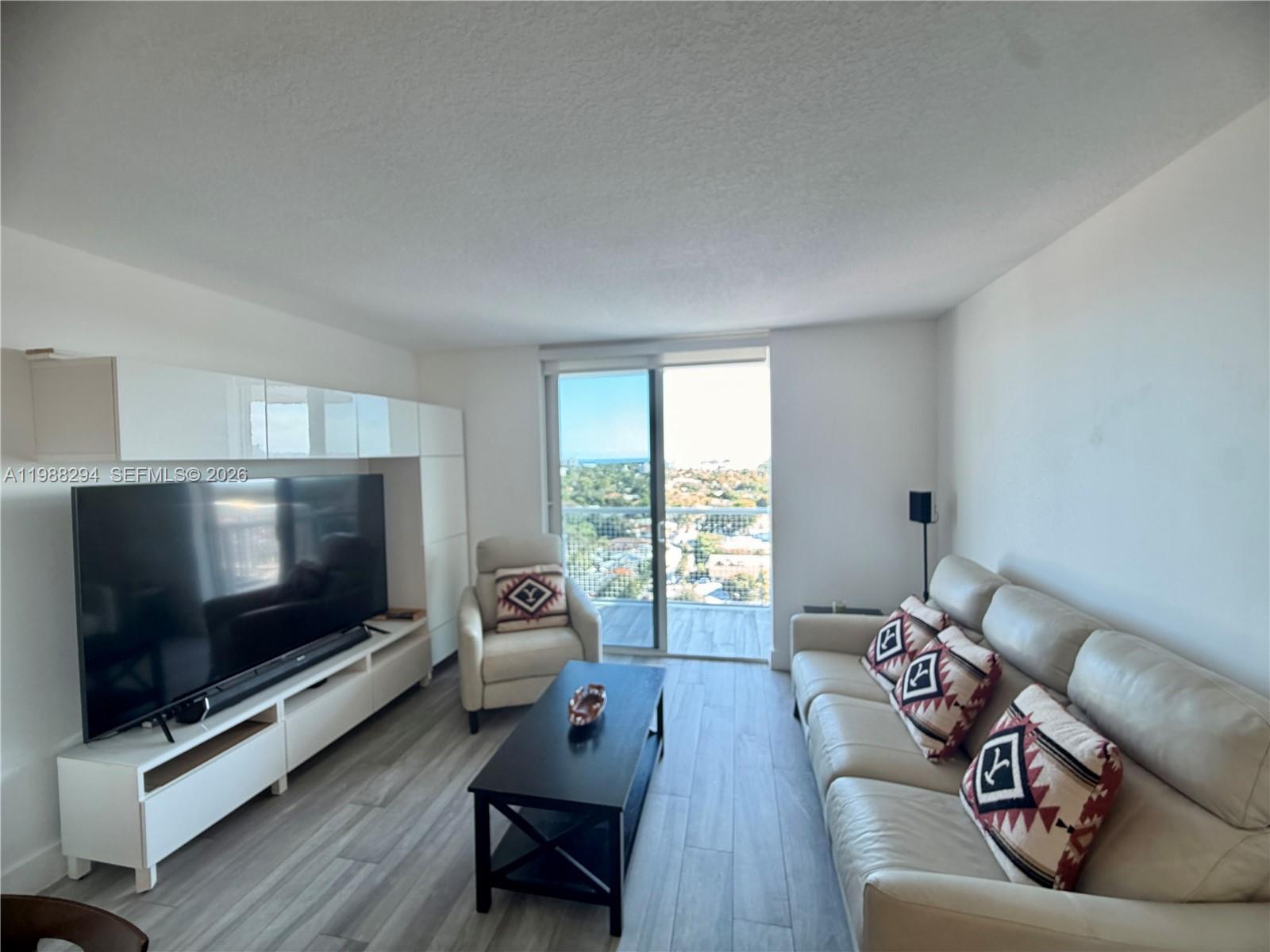 900 Southwest 8th Street, Unit 1509 Miami, FL 33130 - Photo 16 of 37 a living room with furniture and a flat screen tv