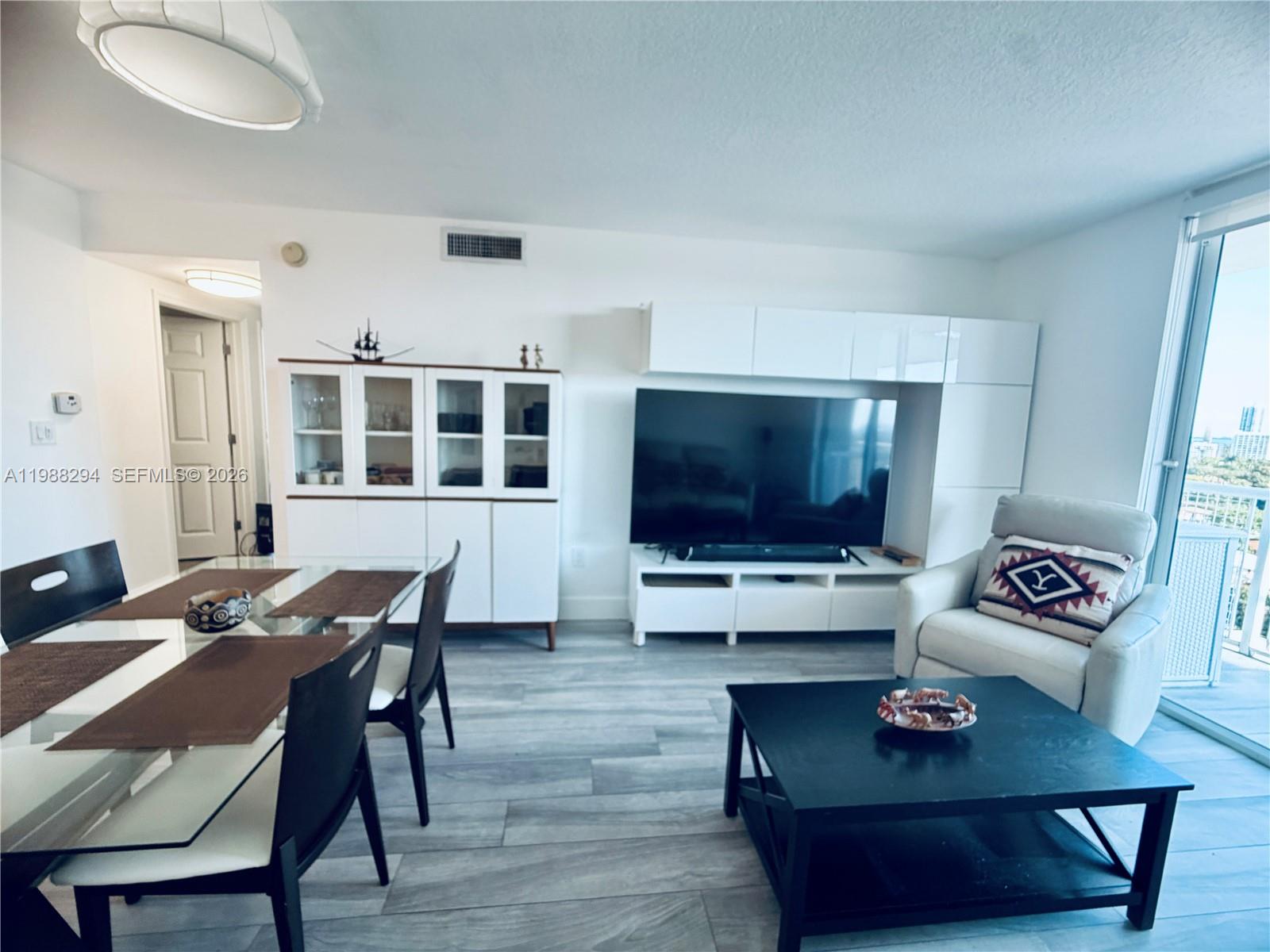 900 Southwest 8th Street, Unit 1509 Miami, FL 33130 - Photo 17 of 37 a living room with furniture and a flat screen tv