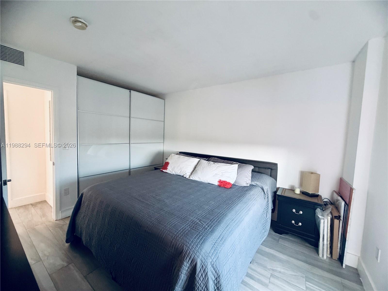 900 Southwest 8th Street, Unit 1509 Miami, FL 33130 - Photo 20 of 37 a bedroom with a bed and a night stand