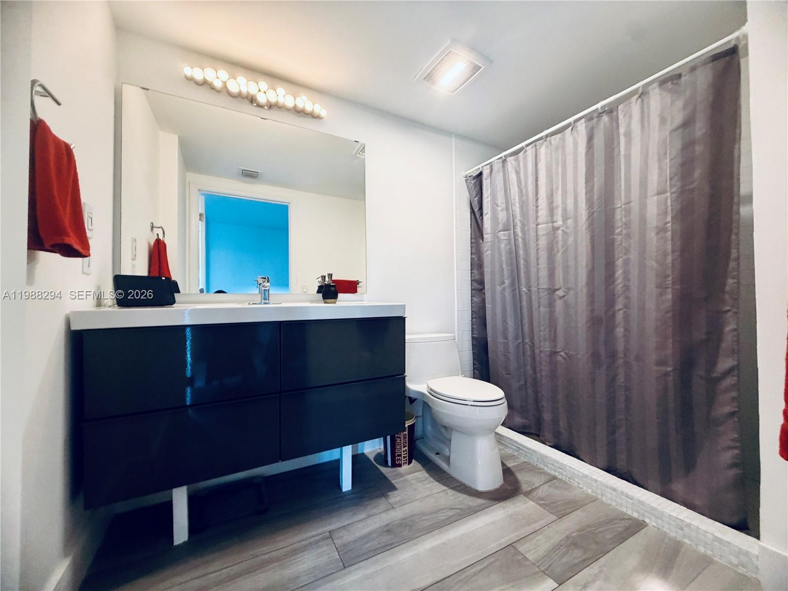 900 Southwest 8th Street, Unit 1509 Miami, FL 33130 - Photo 22 of 37 a bathroom with a toilet a sink and a mirror