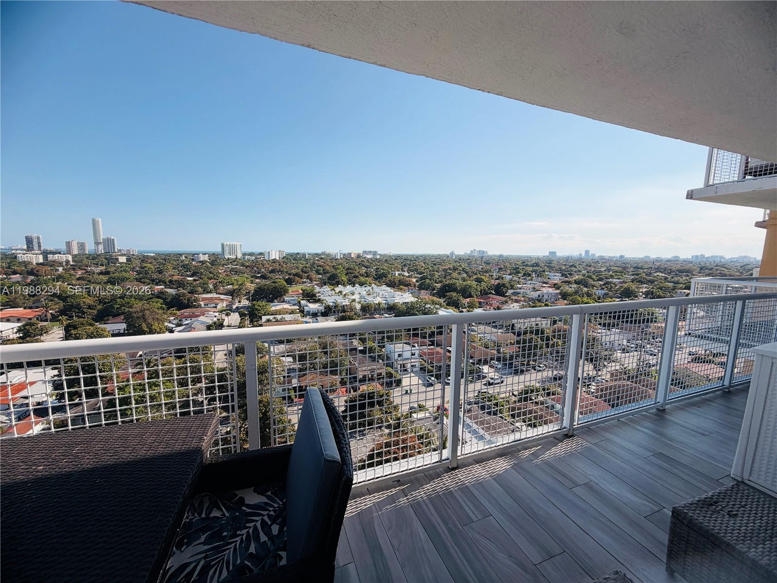 900 Southwest 8th Street, Unit 1509 Miami, FL 33130 - Photo 30 of 37 a view of a balcony with wooden floor chairs and iron fence
