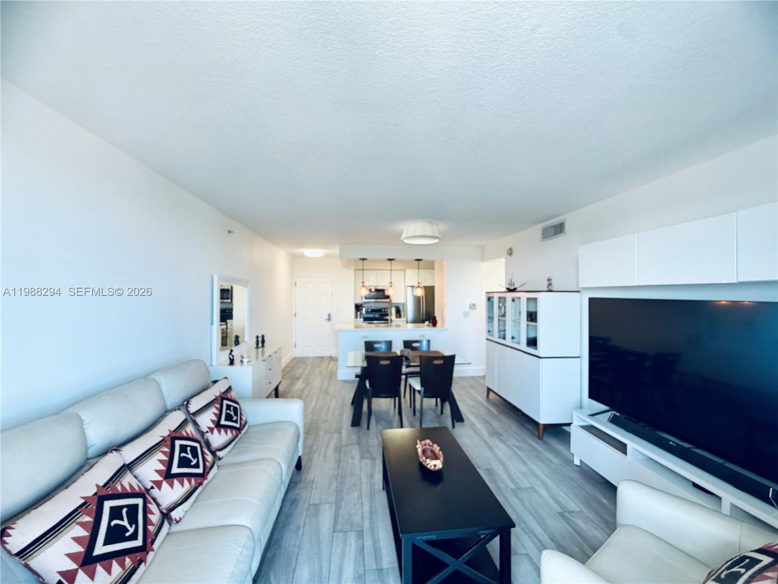 900 Southwest 8th Street, Unit 1509 Miami, FL 33130 - Photo 3 of 37 a living room with furniture and a dining table with kitchen view