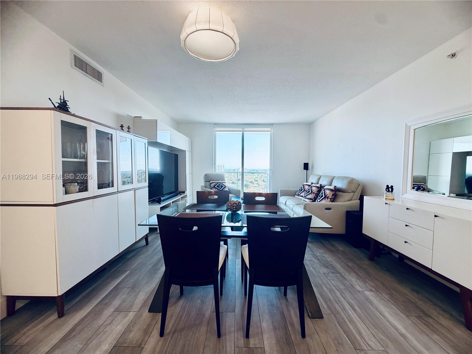 900 Southwest 8th Street, Unit 1509 Miami, FL 33130 - Photo 5 of 37 a kitchen with a dining table chairs and refrigerator