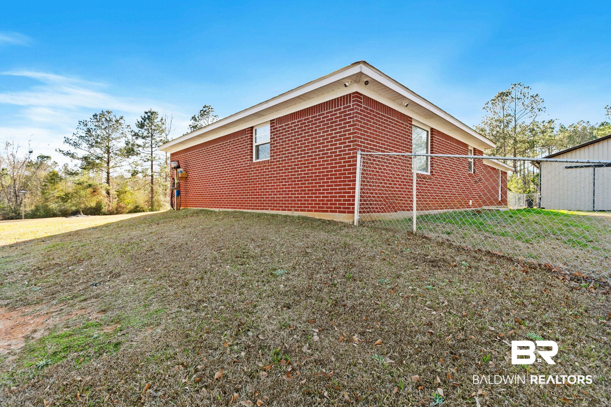 55750 Lottie Road Perdido, AL 36562 - Photo 28 of 84 View of home's exterior featuring a yard and brick siding
