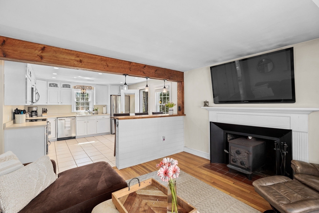 742 Broadway Hanover, MA 02339 - Photo 7 of 42 a living room with furniture a flat screen tv and a fireplace