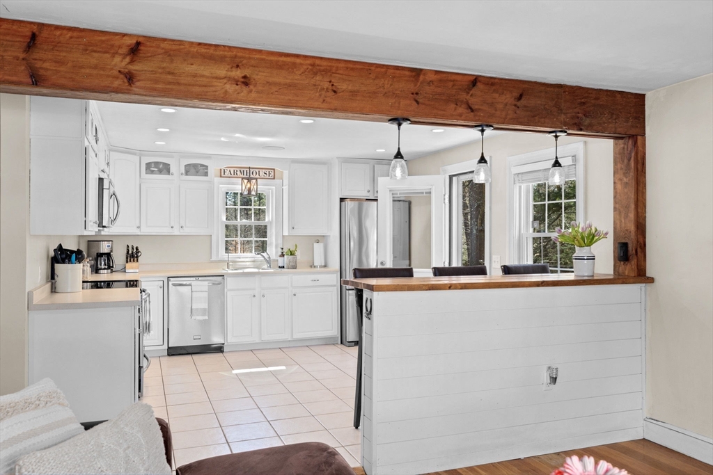 742 Broadway Hanover, MA 02339 - Photo 8 of 42 a large white kitchen with granite countertop a sink and dishwasher a stove top oven with wooden floor