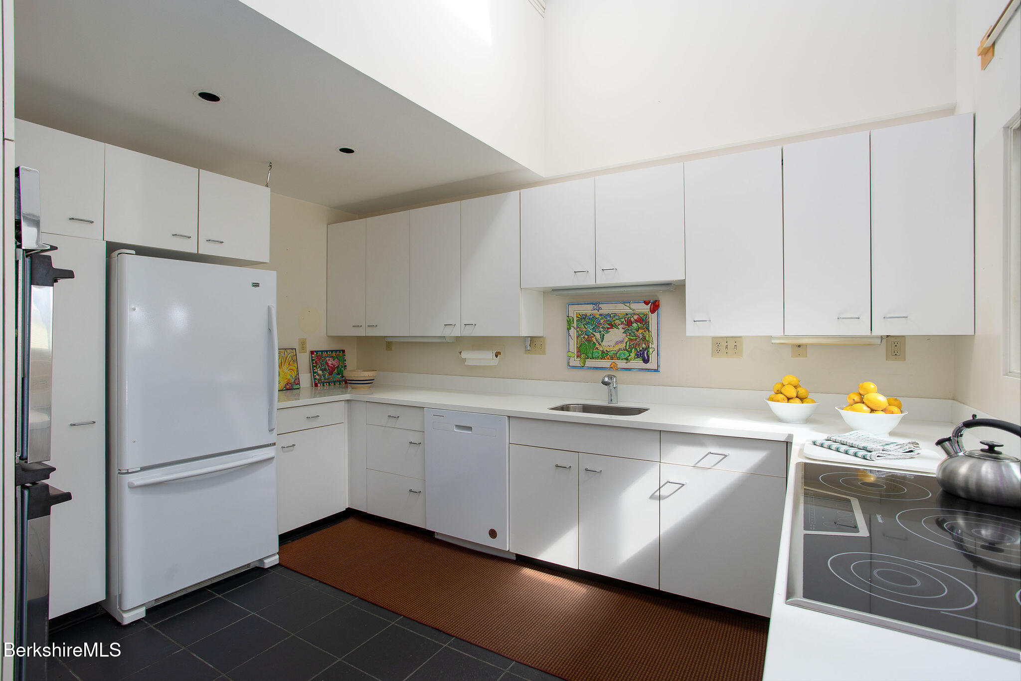 103 Gravesleigh Terrace Pittsfield, MA 01201 - Photo 15 of 46 a kitchen with a sink dishwasher a refrigerator and white cabinets