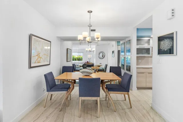 a view of a dining room with furniture a chandelier and wooden floor