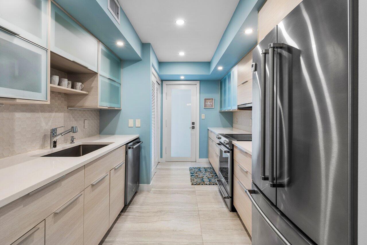 1700 South Ocean Boulevard, Unit 1 Delray Beach, FL 33483 - Photo 16 of 39 a kitchen with stainless steel appliances granite countertop a refrigerator and a sink