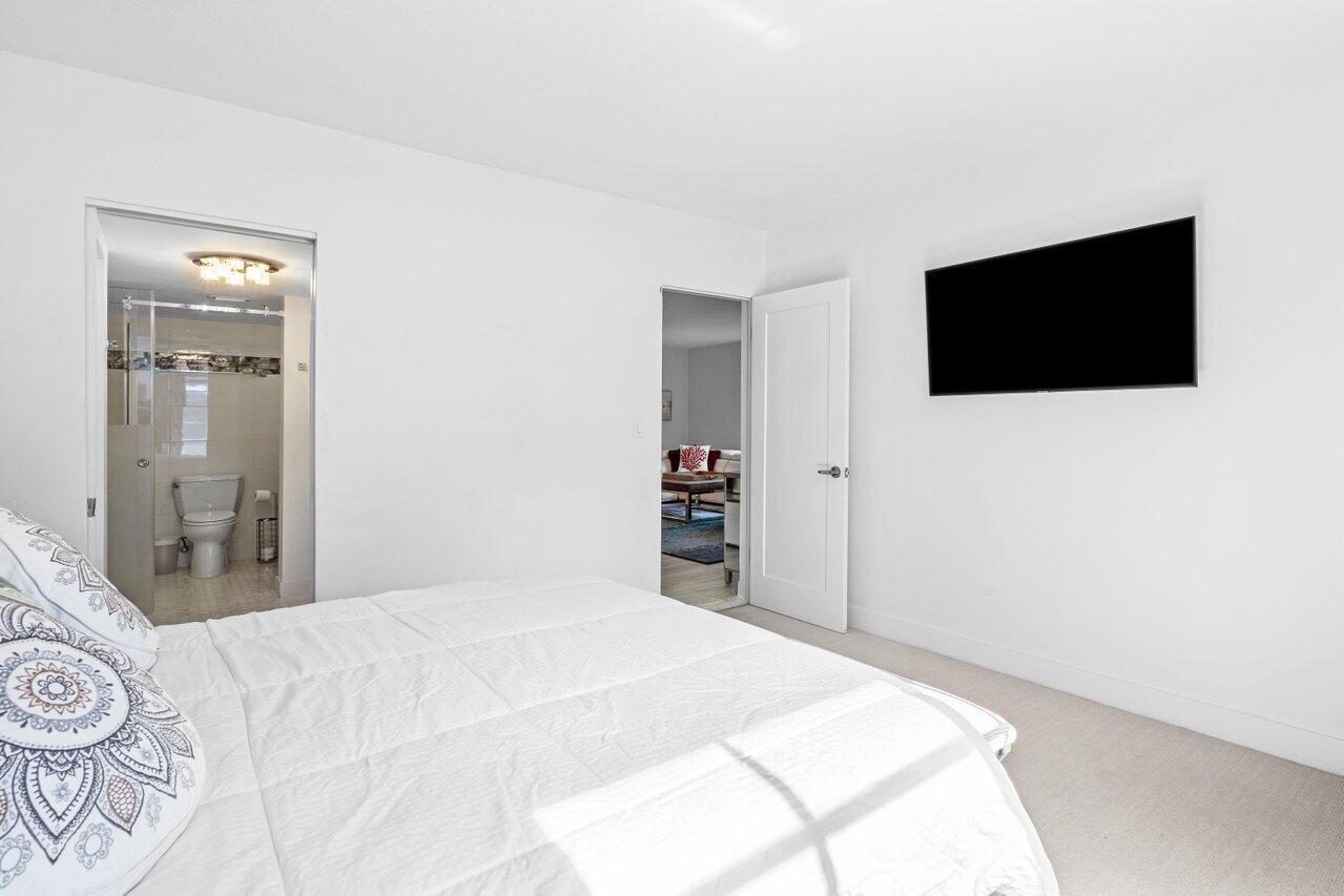 1700 South Ocean Boulevard, Unit 1 Delray Beach, FL 33483 - Photo 20 of 39 a bedroom with a bed and a flat screen tv