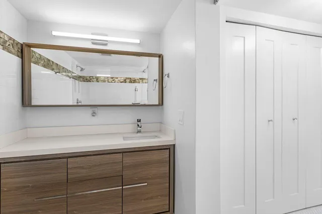 a en suite bathroom with a sink a mirror and shower