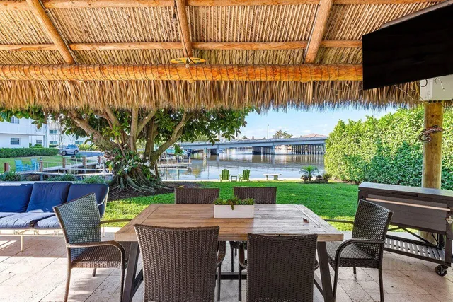a view of a patio with table and chairs potted plants and large tree