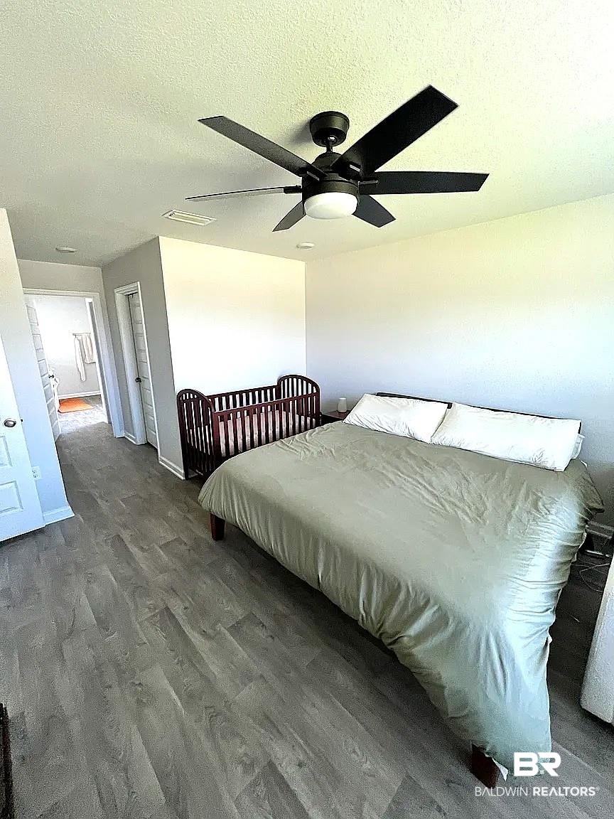 23915 Veranda Circle Elberta, AL 36530 - Photo 15 of 16 Bedroom featuring wood finished floors, a textured ceiling, and a ceiling fan