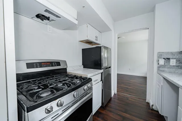 a kitchen with wooden floor and a stove top oven