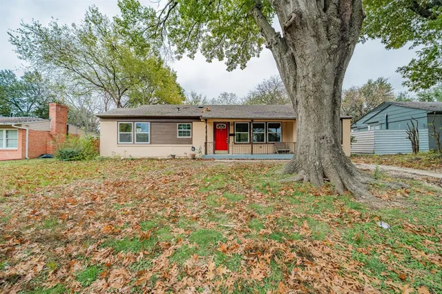 front view of a house with a large tree