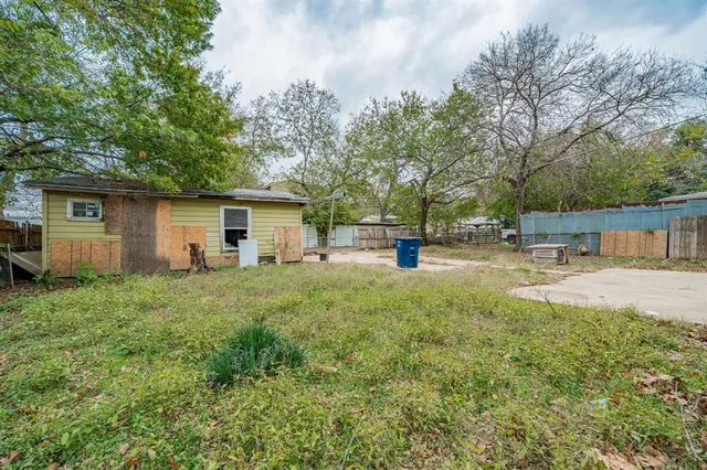 a view of a house with backyard and a tree