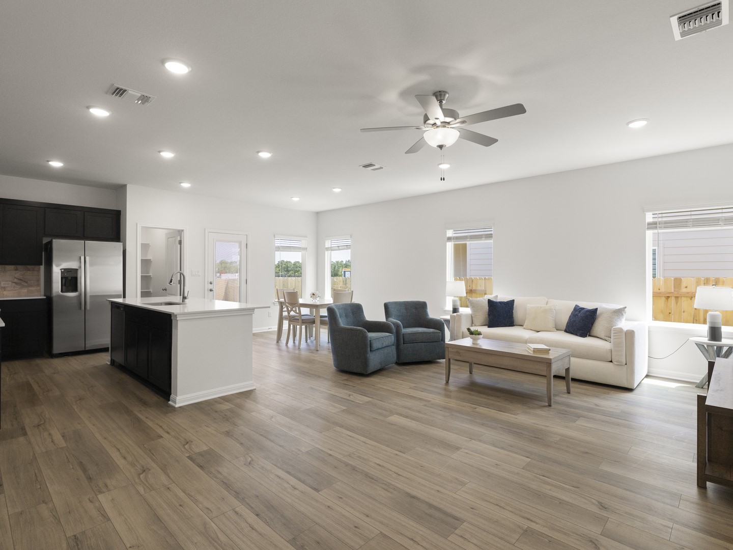 112 Mathew Street Bertram, TX 78605 - Photo 31 of 32 An open floorplan seamlessly connects the kitchen, dining, and living areas with light wood flooring.