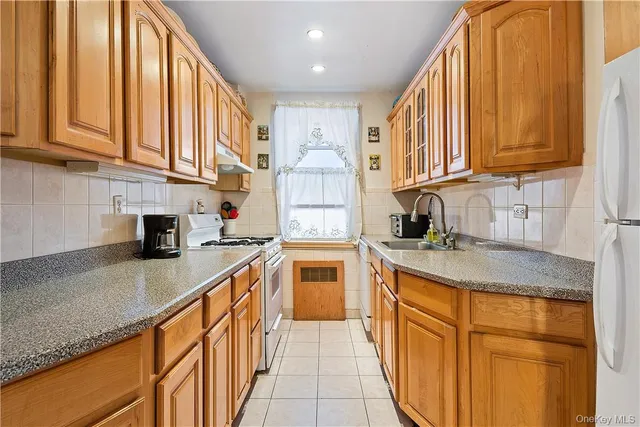 a kitchen with stainless steel appliances granite countertop a stove a sink and a refrigerator