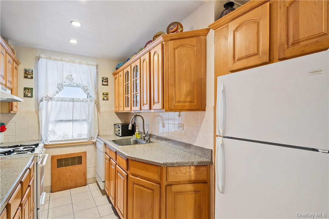 525 West 236th Street, Unit 5B Bronx, NY 10463 - Photo 5 of 18 a kitchen with a sink a stove and a refrigerator